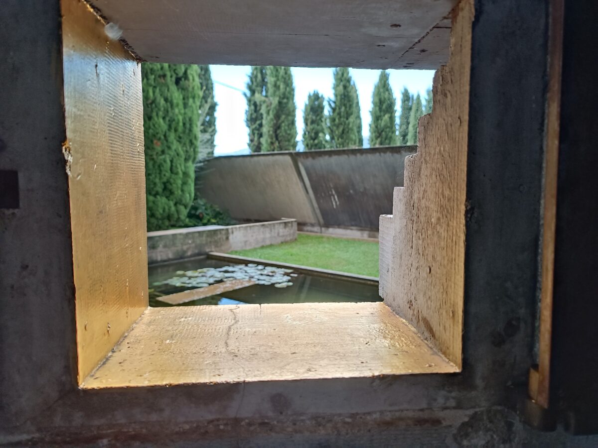 The prato — the simple rectangle of lawn inside the L-shaped enclosure of the Brion tomb.