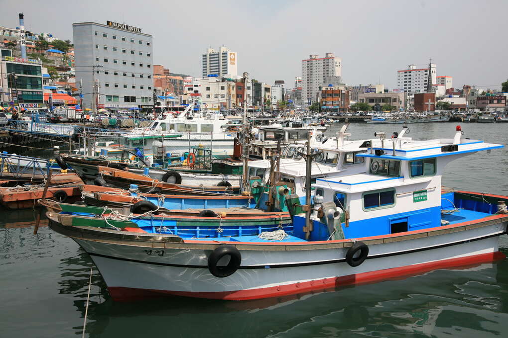 Boats in Tongyeong's harbor with the Hallyeo waterway beyond